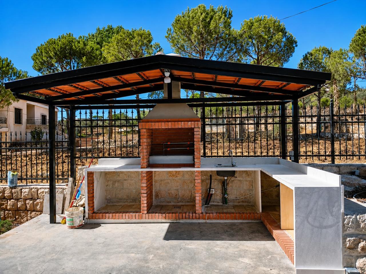 A pergola-covered outdoor kitchen with brick barbecue, Rachaya