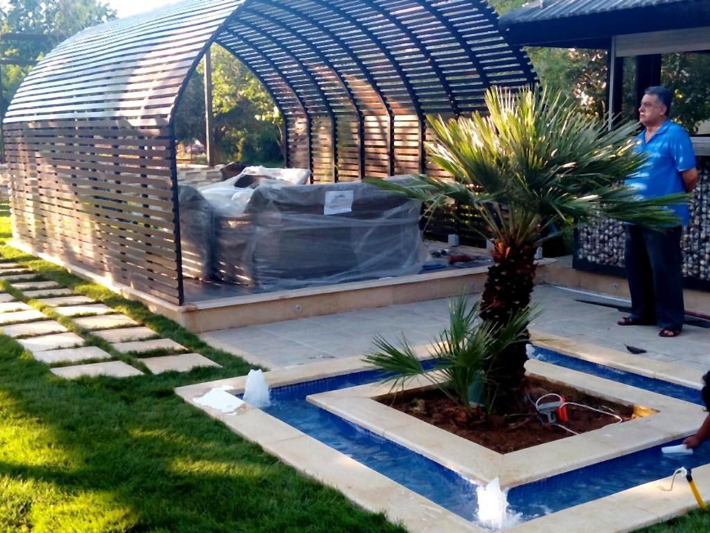 A pergola-covered lounge and reflecting pool with a palm centrepiece, Zahle